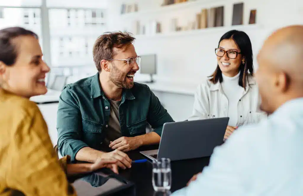 Business-Team bespricht Service-Optimierung am Laptop